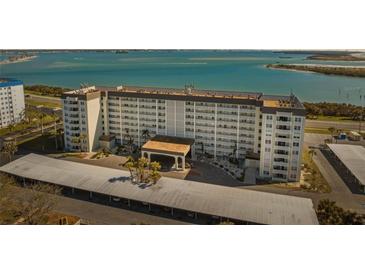 Aerial view of a waterfront condo building with covered parking and tropical landscaping at 9 Forbes Pl # 512, Dunedin, FL 34698