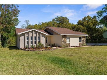 Charming single-story home with a well-manicured lawn and brick and stone accents at 9545 Sunshine Blvd, New Port Richey, FL 34654