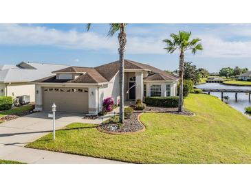 Charming single-story home with a well-manicured lawn, lush landscaping, and two-car garage located waterfront at 1809 Westerham Loop, Trinity, FL 34655