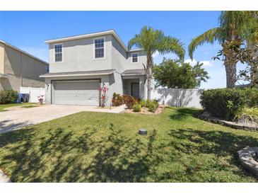 Charming two-story home featuring a well-maintained lawn and tropical landscaping at 1811 Harbour Blue St, Ruskin, FL 33570