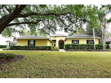 Charming single-story home featuring a lush lawn, arched doorway, and well-maintained landscaping at 19109 Beckett Dr, Odessa, FL 33556