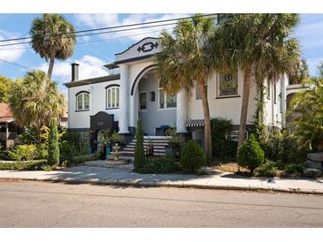 A distinctive house featuring classic architecture, with palm trees accentuating its unique design and appeal at 200 Grand Blvd, Tarpon Springs, FL 34689