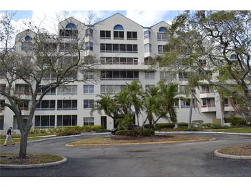 Inviting condo community featuring lush landscaping and a circular driveway at 2333 Feather Sound Dr # A208, Clearwater, FL 33762