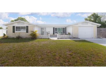 Charming single-story home featuring a well-manicured lawn and a welcoming front entrance with decorative concrete fencing at 2620 Baltic Pl, Holiday, FL 34691