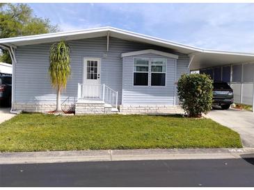 Charming single-story home with light blue siding, well-manicured lawn and covered carport at 34135 Brown Bayou, Wesley Chapel, FL 33543
