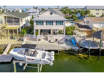 Waterfront home featuring a boat lift, a dock, lush landscaping, and multiple outdoor spaces for relaxing and entertaining at 4058 Centavo Ct, Hernando Beach, FL 34607