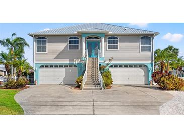 Charming two-story home with a metal roof, featuring double garages and an inviting entryway with painted accents at 4207 Carlos Ct, Hernando Beach, FL 34607