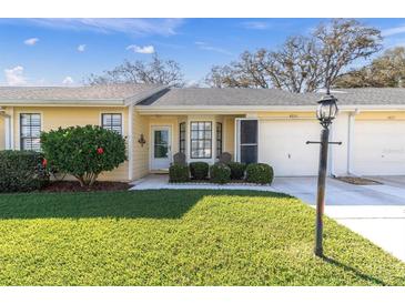 Charming yellow home with a well-manicured lawn and a cozy front porch area perfect for enjoying the outdoors at 4831 Wakefield Ct, New Port Richey, FL 34655