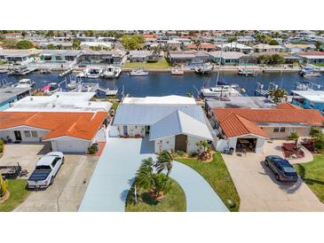 Waterfront home with a metal roof, nicely manicured landscaping, and canal access for boating and other water activities at 4936 Dory Dr, New Port Richey, FL 34652