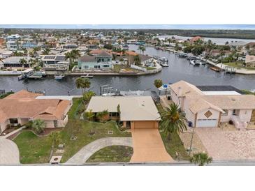 Waterfront home featuring lush landscaping, a private boat dock, and convenient access to waterways at 5000 Southshore Dr, New Port Richey, FL 34652