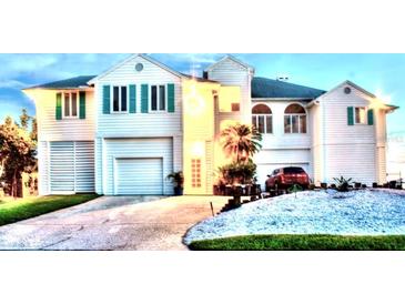 Stunning two-story home with lush landscaping, two-car garage and turquoise window shutters at 121 Augusta Ave, Palm Harbor, FL 34683