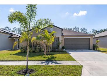 Charming single Gathering home featuring a well-manicured lawn and two car garage at 1957 Fan Aloe Way, Ruskin, FL 33570