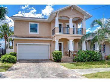 Inviting two-story home features a front balcony, brick paver driveway, and lush landscaping at 2506 W Ivy St, Tampa, FL 33607