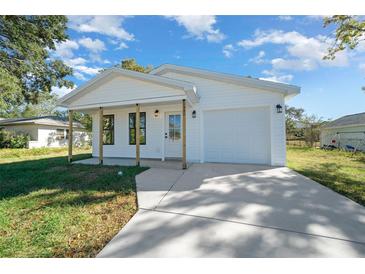 Charming single-story home with white siding, a front porch, and an attached one car garage at 3592 Arrowhead Ave, Spring Hill, FL 34606