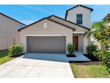 Charming home featuring a two-car garage and landscaped front yard at 6068 Apple Snail Ave, New Port Richey, FL 34653
