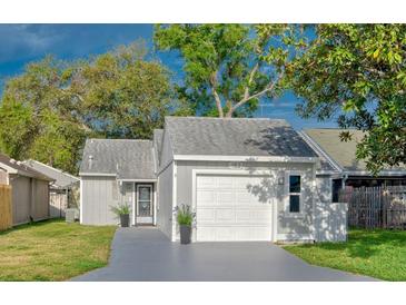 Charming single-story home with an attached garage and well-maintained lawn at 152 Chelsea Ct, Dunedin, FL 34698