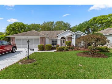 Charming single-story home featuring a well-manicured lawn and beautiful landscaping at 2309 Terrace View Ln, Spring Hill, FL 34606