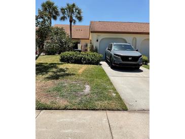 Charming home with a well-maintained front yard and a paved driveway leading to the garage at 3054 Pelican Pl, Clearwater, FL 33762