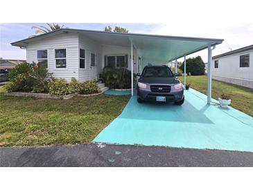Charming single-story home with covered parking and well-maintained landscaping featuring vibrant plants at 5102 Pigeon Plum Cir, New Port Richey, FL 34653