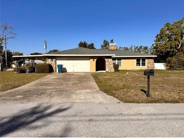 Charming single-story home with stone accents, a covered carport, and an inviting driveway at 2349 Holston Ave, Spring Hill, FL 34608