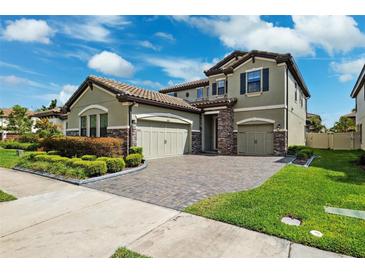 Beautiful two-story home featuring a tile roof, a three-car garage, and lush landscaping at 4012 Dragonfly Trl, Odessa, FL 33556