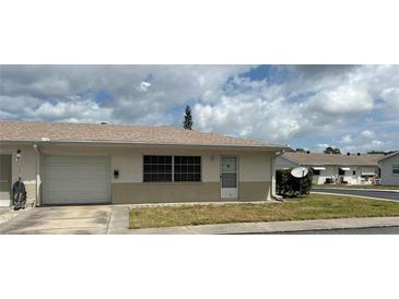 Charming single-story home featuring an attached garage, well-kept lawn, and neutral brick accents at 5335 Embassy Ave # 5335, New Port Richey, FL 34652