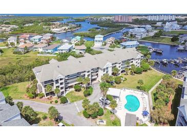 An aerial view of a waterfront condominium with a pool and canal access in a beautiful coastal setting at 5537 Sea Forest Dr # 301, New Port Richey, FL 34652