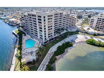 Stunning aerial view of waterfront condo building with pool, beach access, and lush landscaping at 6035 Sea Ranch Dr # 305, Hudson, FL 34667
