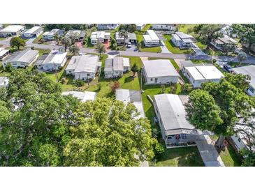 An aerial view showcases the neighborhood with mature trees and well-maintained homes at 6124 Crestview Ln, Zephyrhills, FL 33542