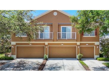 Charming townhouse with a multi-car garage, tan exterior, and delightful balcony spaces at 6821 Breezy Palm Dr, Riverview, FL 33578