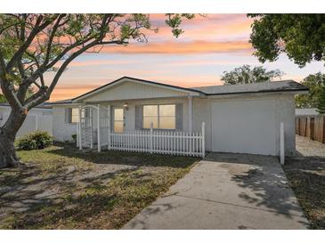 Charming single-story home featuring a well-maintained front yard and inviting curb appeal at sunset at 7034 N King Arthur E Dr # 4, Port Richey, FL 34668