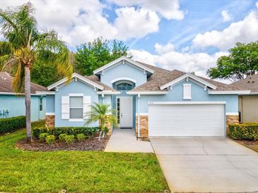 Charming single-story home featuring a well-manicured lawn and an attached two-car garage at 11050 Kiskadee Cir, New Port Richey, FL 34654
