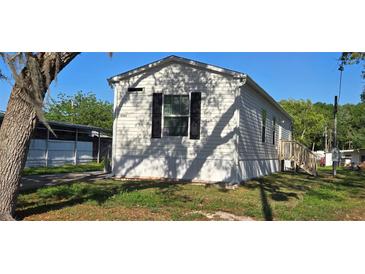 Charming single-story home with white siding and black shutters, nestled in a lush green lawn at 11304 Altoona Ave, New Port Richey, FL 34654