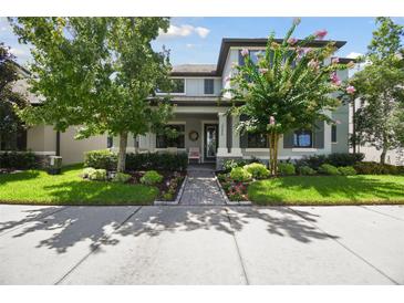 Charming two-story home with landscaped yard and a cozy front porch with rocking chairs at 12272 Rangeland Blvd, Odessa, FL 33556