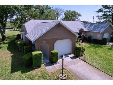 Charming single-story home featuring a well-maintained lawn, trimmed hedges, and attached one car garage at 4836 Alamo Ct, New Port Richey, FL 34655