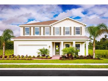 Beautiful two-story home featuring a front yard with palm trees and a two-car garage at 6770 Pebblebrooke Way, Zephyrhills, FL 33541