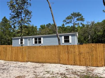 Charming single-story home with light blue siding and a newly installed wooden fence at 11444 Lake Dr, New Port Richey, FL 34654