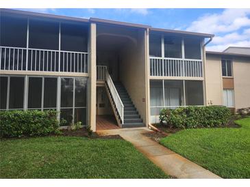 Condo exterior shows walkway, stairs, and tan paint scheme at 12119 Sunny Glen Ln # G2, Hudson, FL 34669