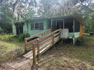 Exterior view of a single story home featuring a ramp and a screened-in porch at 13120 Davista Ave, New Port Richey, FL 34654