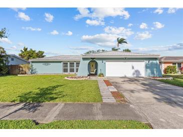 Charming single-story home with a well-manicured lawn and a two-car garage in a quiet residential neighborhood at 155 Patty Ann Blvd, Palm Harbor, FL 34683