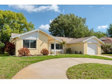 Charming one-story home with a brick facade, well-maintained lawn, and a curved driveway at 8505 Lincolnshire Dr, Hudson, FL 34667