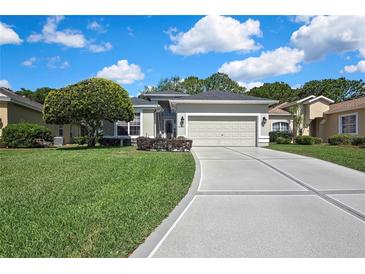 Charming single-story home boasts a well-manicured lawn and an attached two-car garage with a concrete driveway at 10109 Holly Berry Dr, Spring Hill, FL 34613