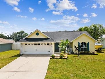 Charming home with a well-manicured lawn, two-car garage, and inviting curb appeal at 11630 Pasadena Rd, Dade City, FL 33525