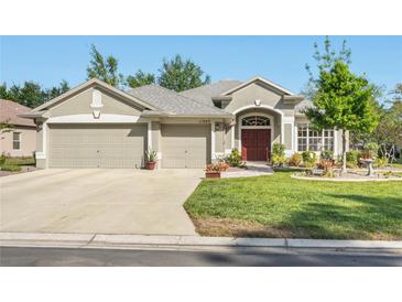 Charming single-story home featuring a well-manicured lawn and a three-car garage at 11949 Wexford Blvd, Spring Hill, FL 34609