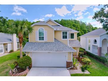 Charming yellow two-story home with a well-manicured lawn and attached two-car garage at 16022 Westerham Dr, Tampa, FL 33647