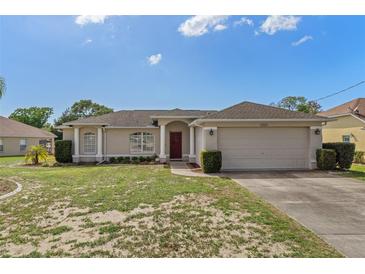 Charming single-story home with a well-manicured lawn, classic architectural details, and an attached two-car garage at 3345 Carmen Ave, Spring Hill, FL 34609