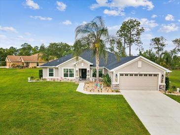 Beautiful single-story home features a well-manicured lawn and attached two-car garage at 3455 Whispy Ct, Spring Hill, FL 34609