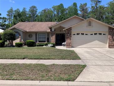Charming single-story home with a manicured front yard, well-maintained lawn, and a two car garage at 5045 Musselshell Dr, New Port Richey, FL 34655