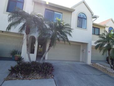 Charming townhome with attached garage and well-maintained landscaping featuring lovely palm trees in a desirable community at 545 Walden Ct, Dunedin, FL 34698