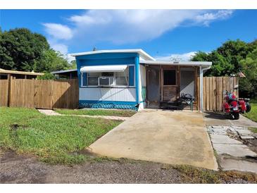 Charming single-story home with blue and white trim, a small front yard, and a motorcycle parked outside at 6507 Ginny Dr, Port Richey, FL 34668